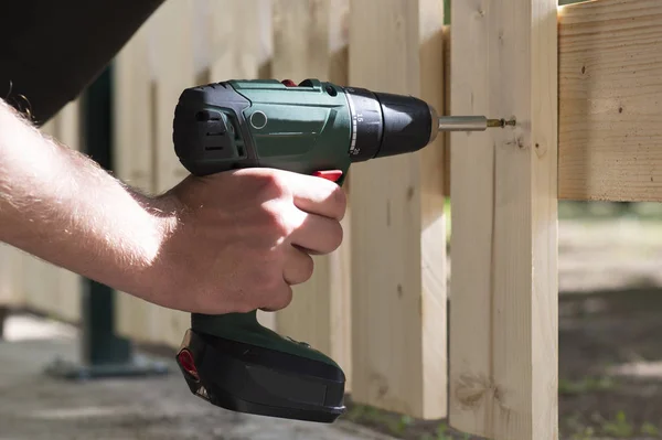 Male hand holding drill-drive while screwing screw — Stock Photo, Image