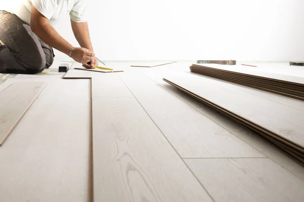 Homem instalando piso laminado em casa nova — Fotografia de Stock