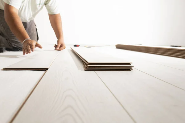 Hombre instalación de piso laminado en casa nueva —  Fotos de Stock