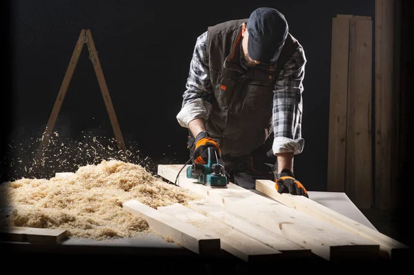Carpenter works with electrical planer — Stock Photo, Image