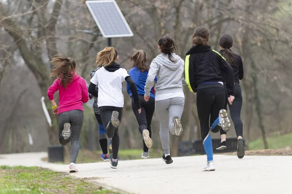 Fitness, sport, friendship, race and healthy lifestyle concept - group of happy teenage friends or sportsmen running marathon