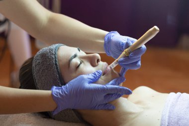 Spa, tatil köyü, güzellik ve sağlık konsepti. Güzellik salonunda yüz bakımı gören güzel bir kadın. Yüz bakımı. Kozmetoloji 