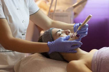 Spa, tatil köyü, güzellik ve sağlık konsepti. Güzellik salonunda yüz bakımı gören güzel bir kadın. Yüz bakımı. Kozmetoloji 