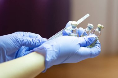 Kadının elinde şırınga tutan tıbbi eldivenler var. Vücudunla ilgilenme konsepti