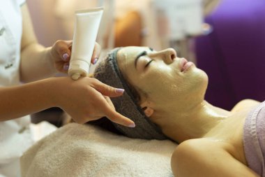 Yüz soyma maskesi, kaplıca güzellik tedavisi, cilt bakımı. Güzellik salonundaki kadın yüz bakımını alıyor. Yan görüş, yakın çekim.