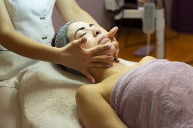 Yüz masajı güzellik tedavisi. Kadın hasta profesyonel terapist tarafından tedavi ediliyor.