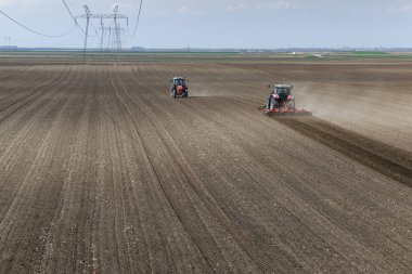 Hava manzarası - tarlada çalışan iki traktör, tarlayı ekime hazırlıyor, tarlayı sürüyor