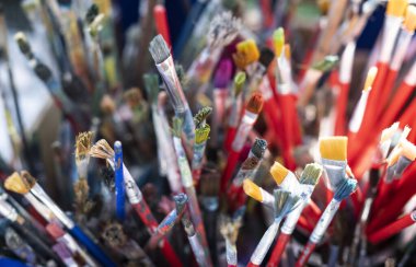 Kovada bir sürü kirli boya fırçası var. Farklı sanatçı fırçaları, yakın çekim görüntüsü