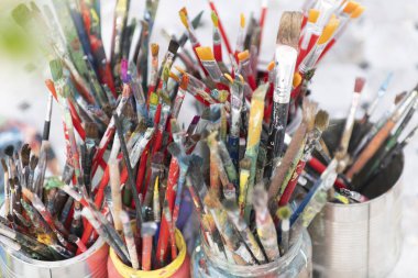 Kovada bir sürü kirli boya fırçası var. Farklı sanatçı fırçaları, yakın çekim görüntüsü