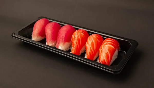 Salmon sushi and tuna sushi on black background.