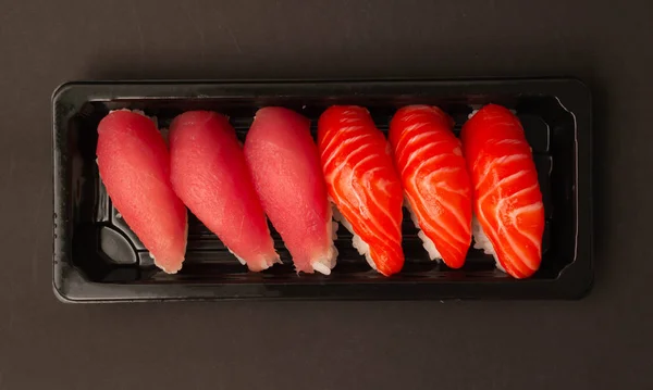 Salmon sushi and tuna sushi on black background. — Stock Photo, Image