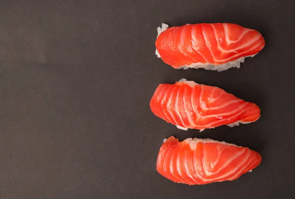 Salmon sushi on black background. — Stock Photo, Image