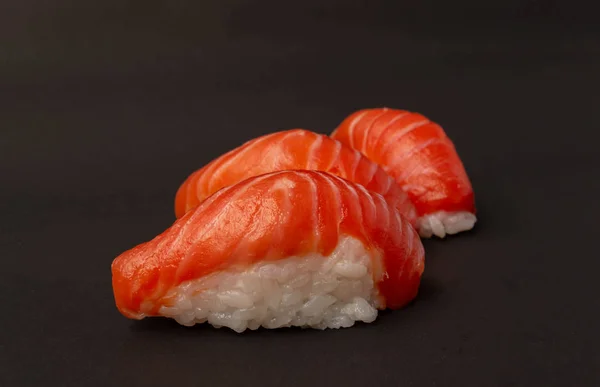 Salmon sushi on black background. — Stock Photo, Image