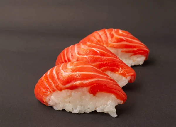 Salmon sushi on black background. — Stock Photo, Image