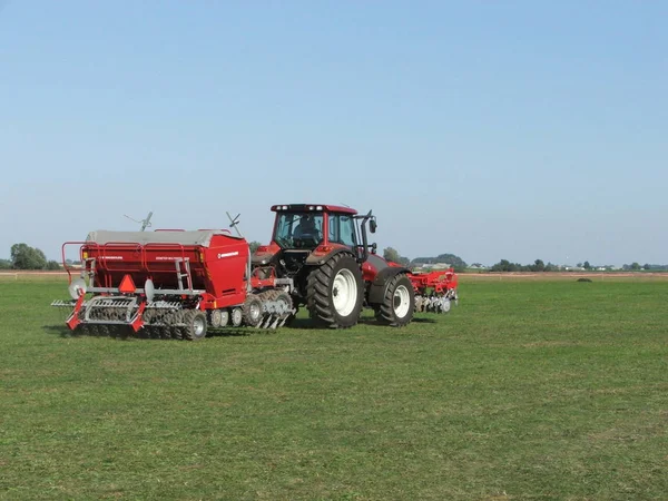 Burgonyaültetvényes vörös traktor — Stock Fotó