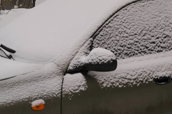 A fragment of a car with a mirror covered with a layer of snow on a clear winter day. — Stock Photo, Image