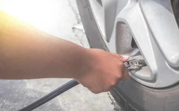 Filling air into a car tire — Stock Photo, Image