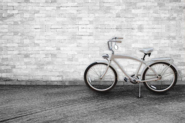 Bicicleta no fundo da velha parede de tijolo branco vintage na estrada — Fotografia de Stock
