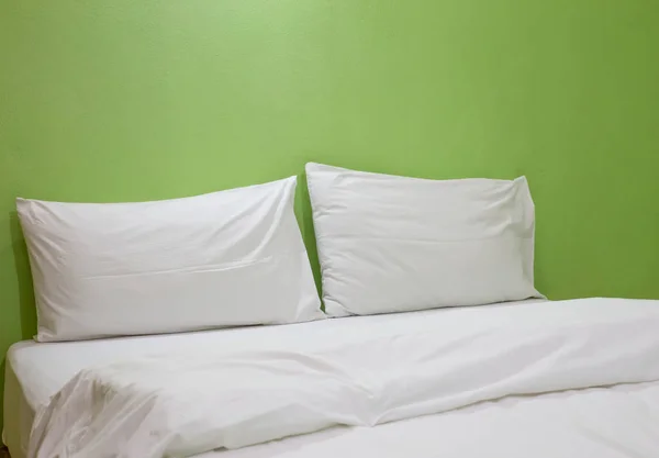 Un lit non fait avec fond de lin blanc vert — Photo