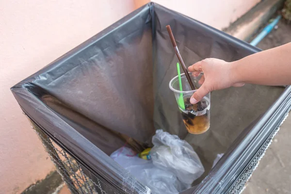 Woman\'s Hand throwing scarp of cup into recycling bin, hand hold