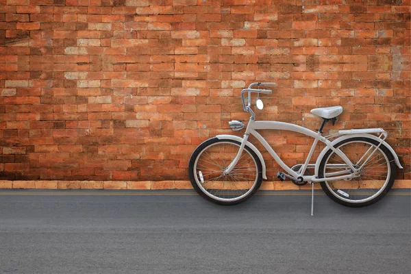 Bicicleta no fundo da velha parede de tijolo branco vintage na estrada — Fotografia de Stock