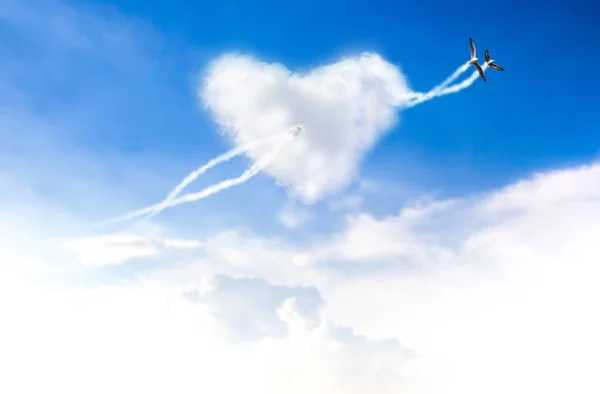 L'amour est dans les deux oiseaux volant ciel bleu avec des cœurs en forme de nuages — Photo