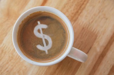 Ahşap arka plan üzerinde beyaz bir fincan kahve ile dolar.