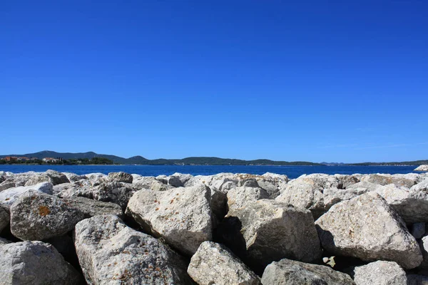 Adriyatik Denizi kıyısında. Sahilde taş. Güneşli gün.