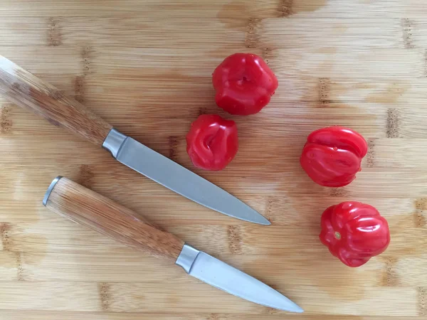 Tomatoes on the bamboo board with knives