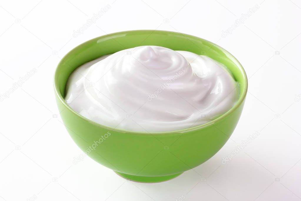 cream sour in a plate isolated white backround