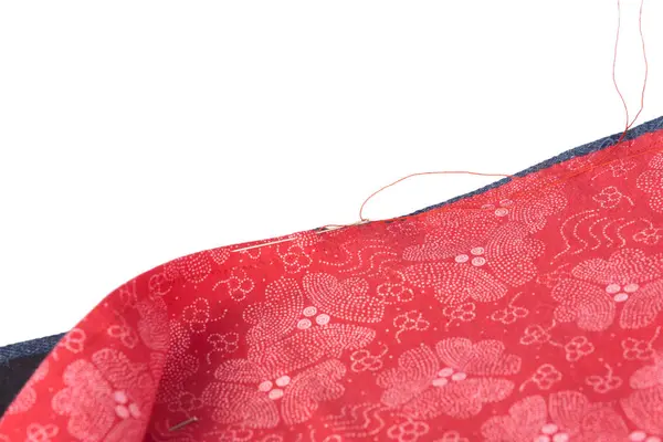 İğne ve pamuklu kırmızı çiçekli kumaş, ışık arkaplanındaki fotokopi alanı ile yakın çekim konsepti, dikiş, dikiş ya da onarım