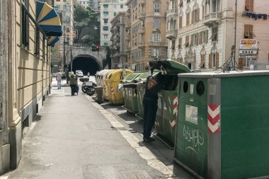 Genoa, İtalya - Haziran, 9 2017 - göçmen yiyecek içinde çöp Çöp konteyner