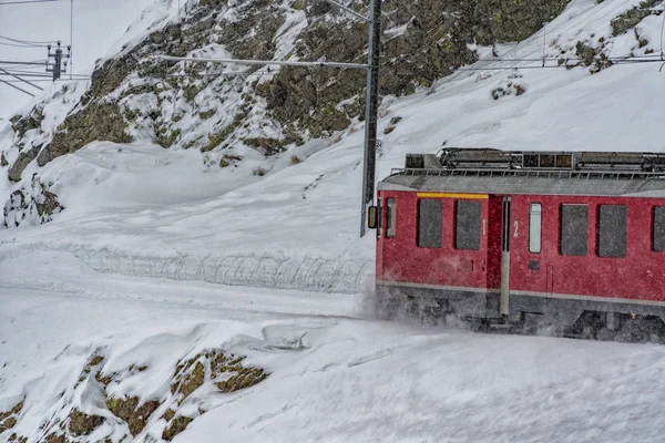 Czerwony pociąg w śniegu w Alpach Szwajcarskich — Zdjęcie stockowe
