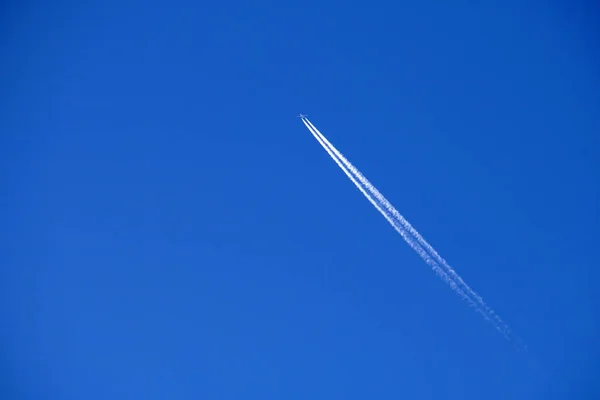 Trilhas de avião trilhas chemtrails no céu azul profundo — Fotografia de Stock