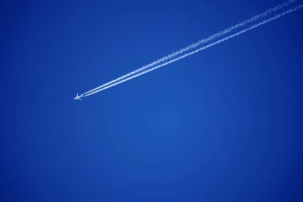 Repülőgép nyomvonal pályák chemtrails, a mély kék égen — Stock Fotó