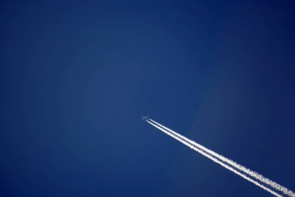 Repülőgép nyomvonal pályák chemtrails, a mély kék égen — Stock Fotó