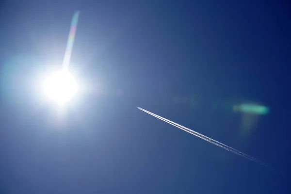 Trilhas de avião trilhas chemtrails no céu azul profundo — Fotografia de Stock