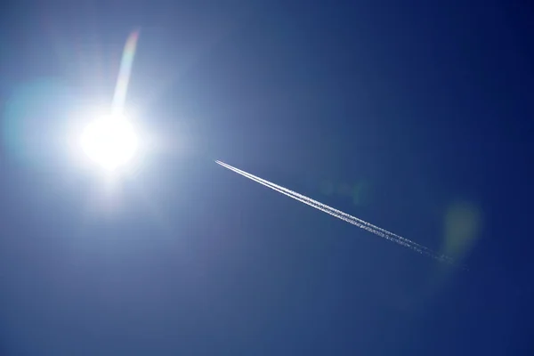 Trilhas de avião trilhas chemtrails no céu azul profundo — Fotografia de Stock