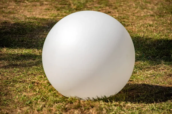 White sphere isolated on green grass — Stock Photo, Image