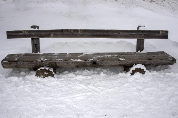 Banco de madeira coberto por neve e gelo — Fotografia de Stock