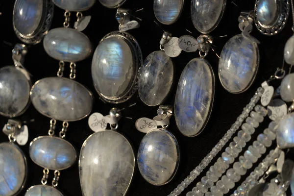 Arco iris piedra lunar pendientes de joyería en el stand de exhibición en un mercado de la tienda —  Fotos de Stock