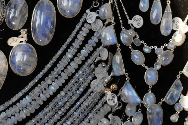 Arco iris piedra lunar pendientes de joyería en el stand de exhibición en un mercado de la tienda —  Fotos de Stock