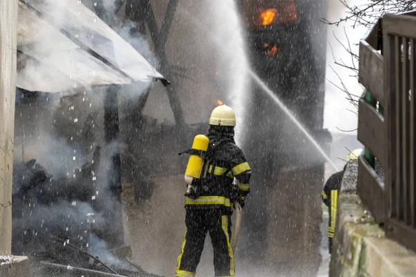 Bomberos luchando contra un fuego en casa —  Fotos de Stock