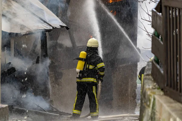 Bombero luchando contra un fuego en casa —  Fotos de Stock