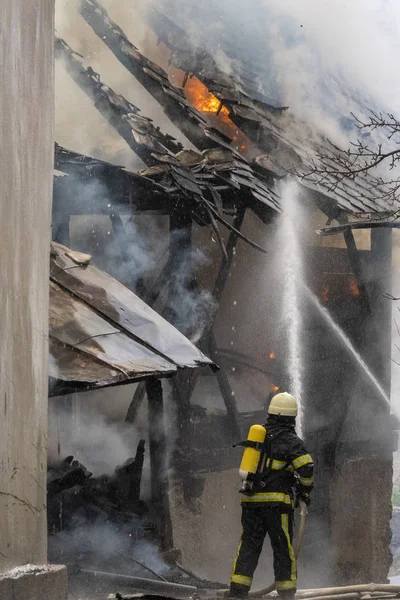 Пожарный борется с пожаром в доме — стоковое фото