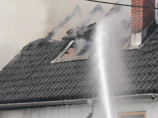 Bombero luchando contra un fuego en casa —  Fotos de Stock