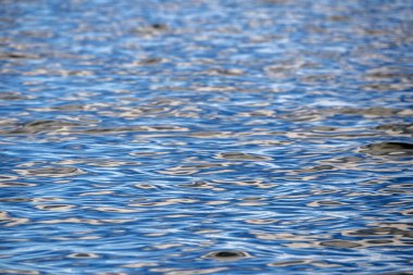 Denizin doğal dokusunda gün batımı yansıması