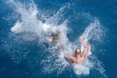 Maldivler cennetinde suya atlayan insanlar.