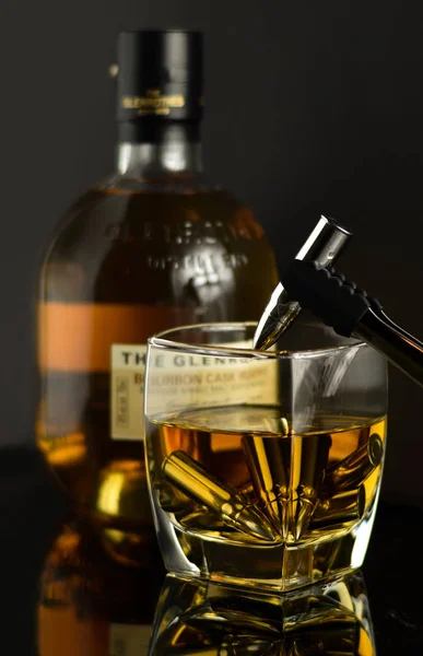 Viski bardağındaki mermiler şişelerin yanında.