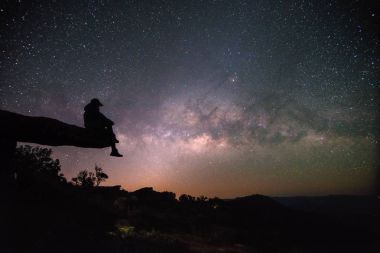 Kadın taş lodge Samanyolu altında oturur